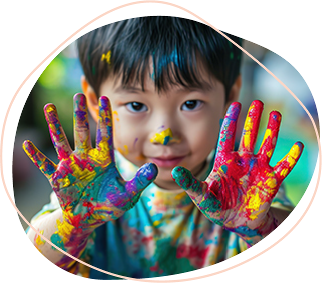 A child with their hands outstretched covered in different pain colours