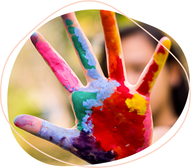 An open hand covered in different colours of paint