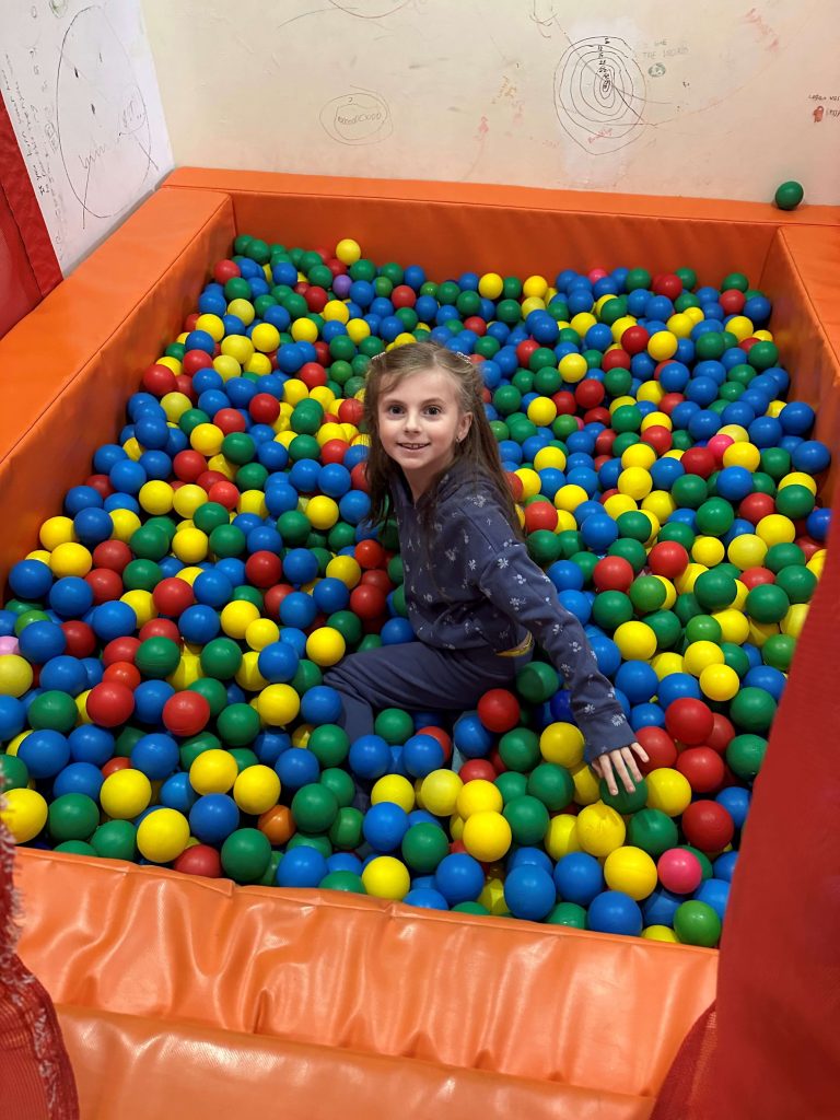 A child playing in a ball pit