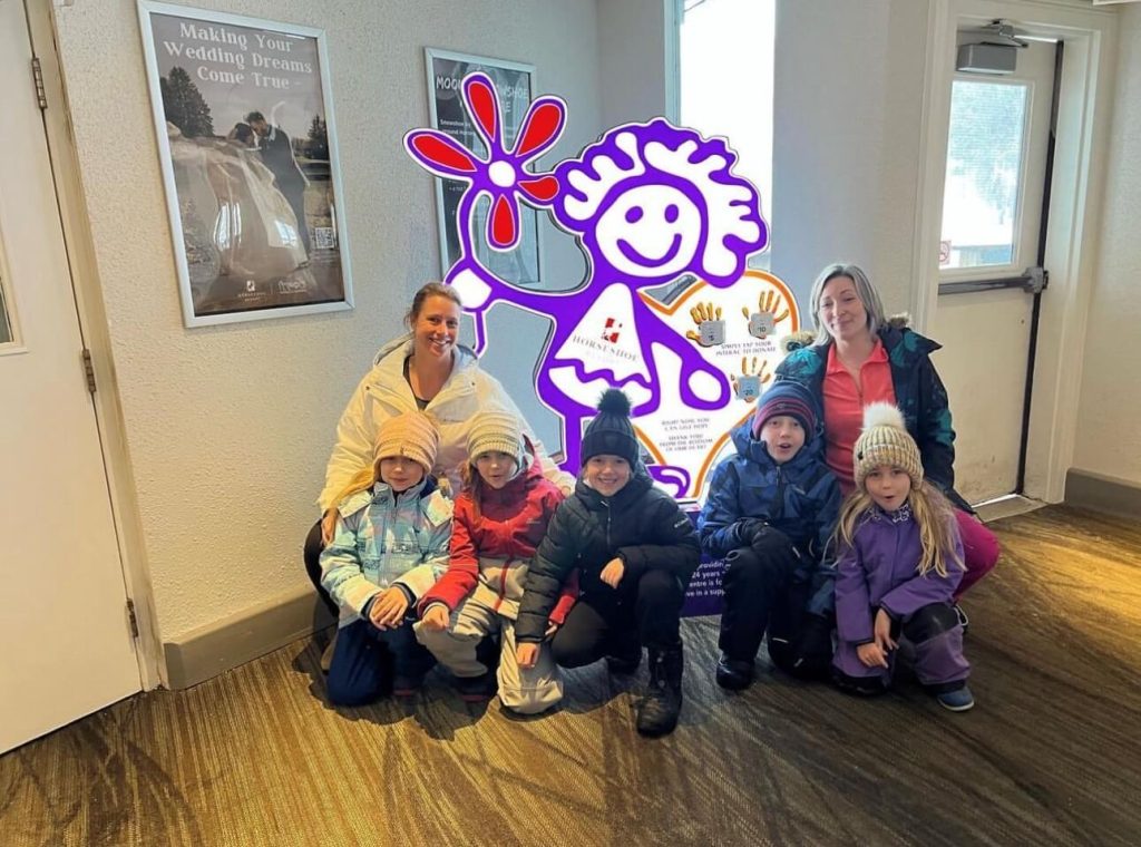 An image of a group of children smiling for a photo in front of Hope